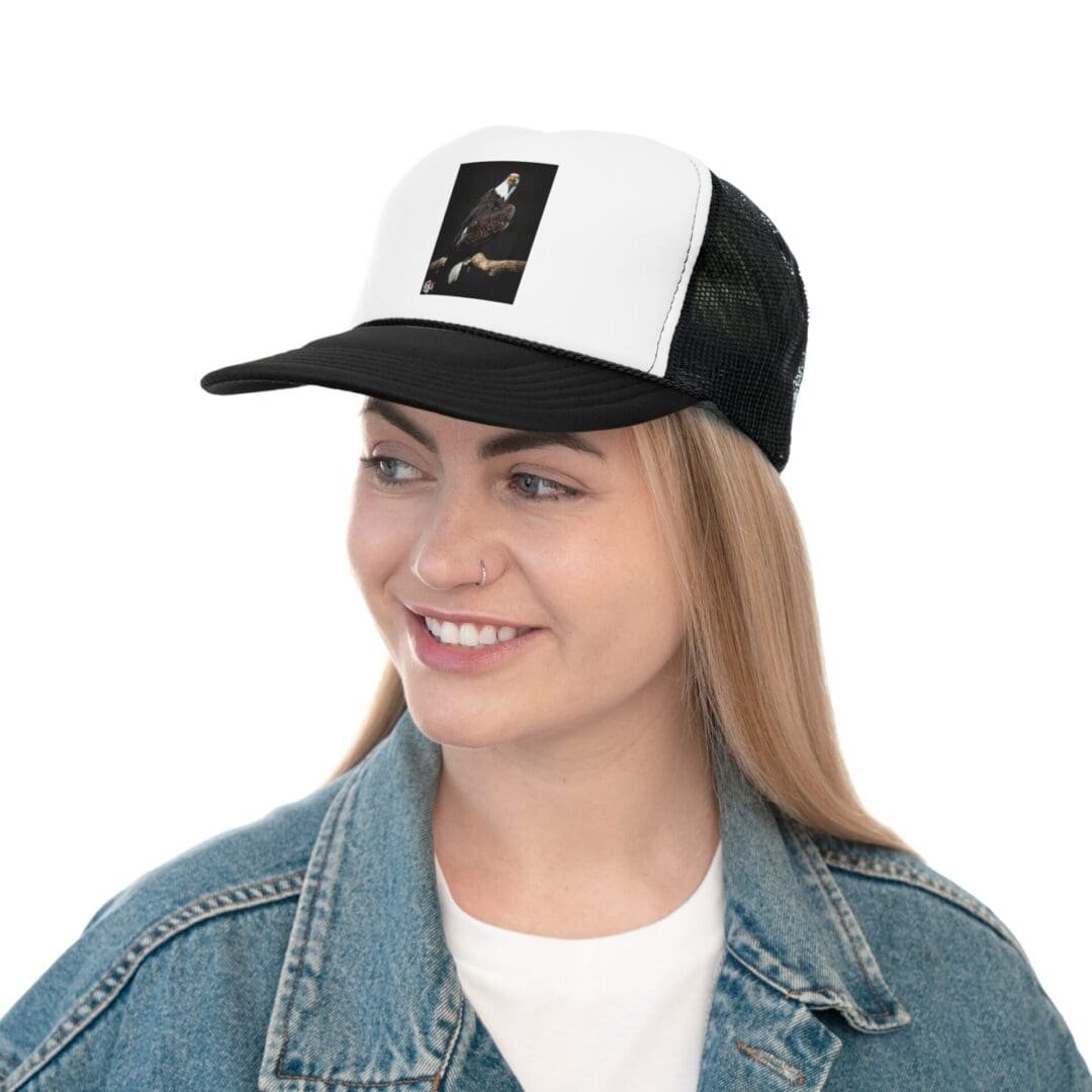 Young woman smiling wearing a black and white trucker hat.