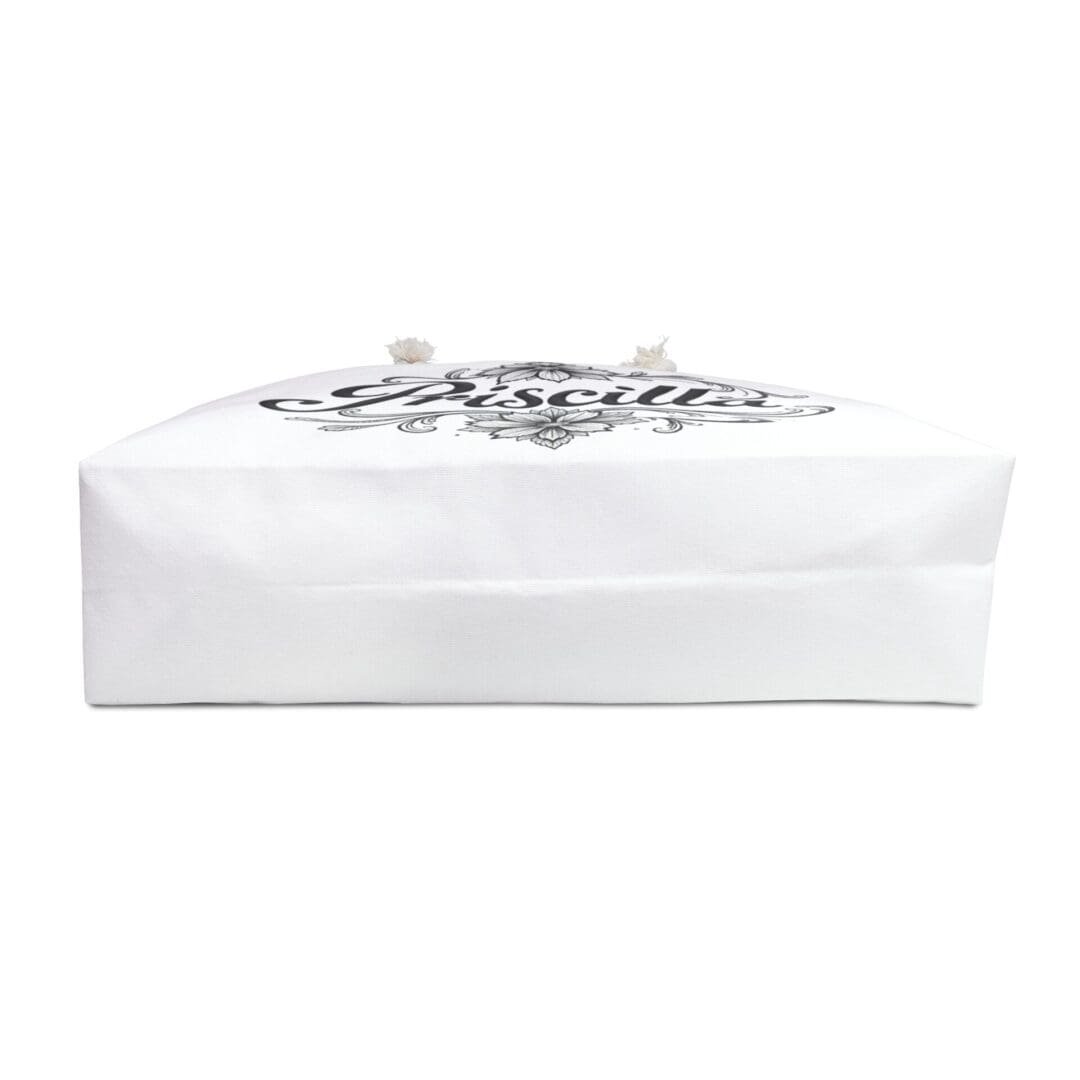 White folded cloth with a black printed design on top.