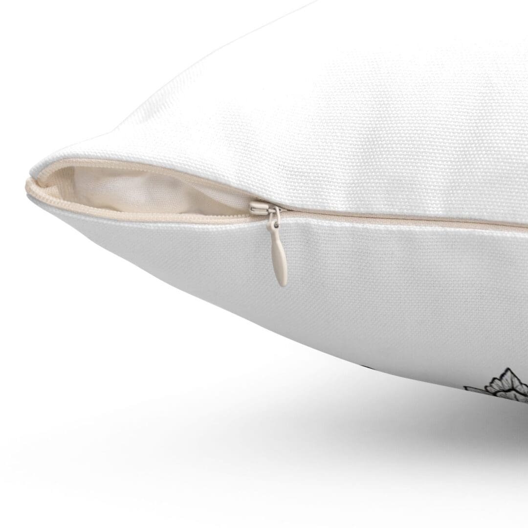 Close-up of a beige pillow with a zipper partially open.